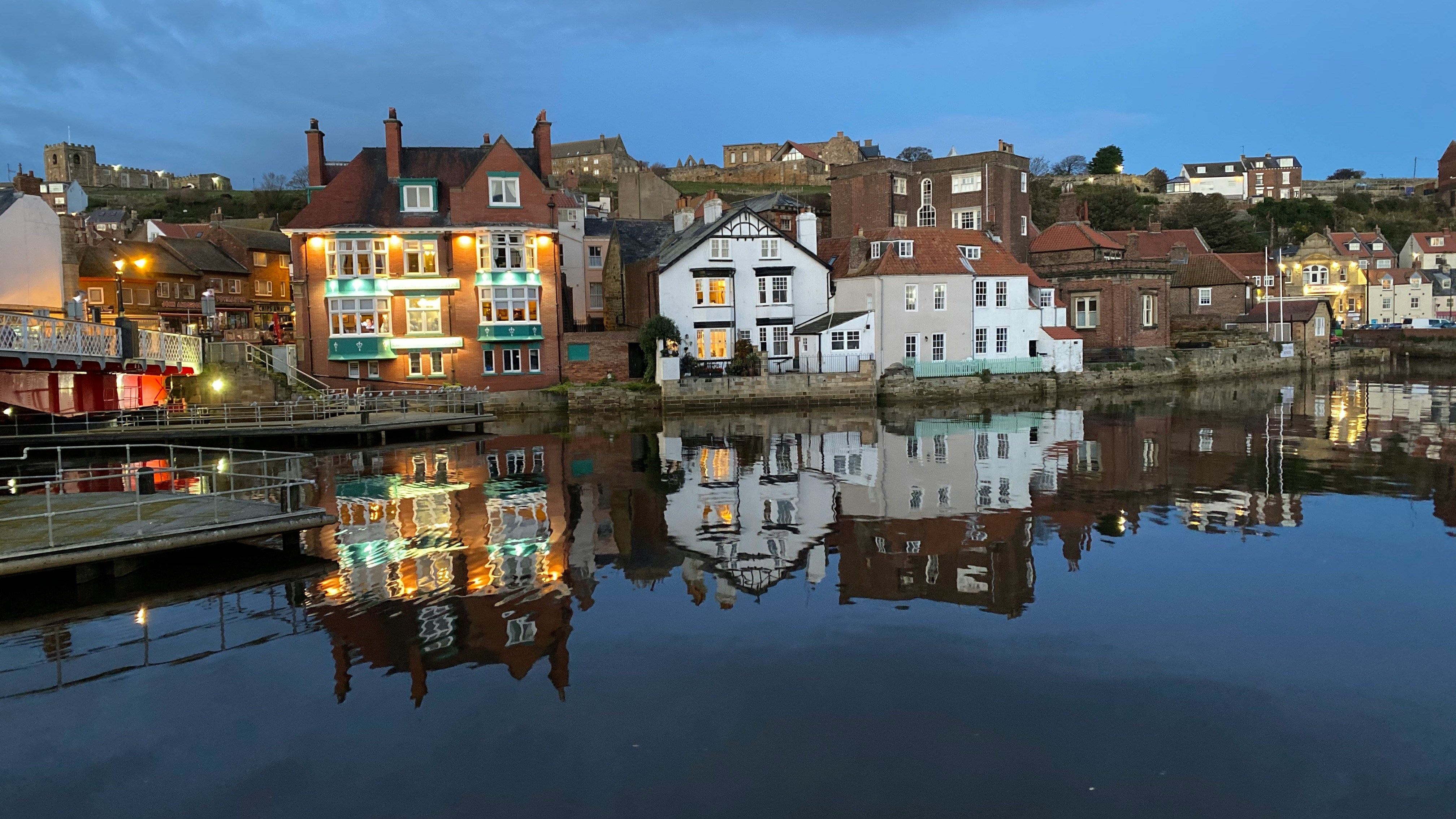 Buildings and waterfront reflected in the River Esk at Whitby harbour in North Yorkshire